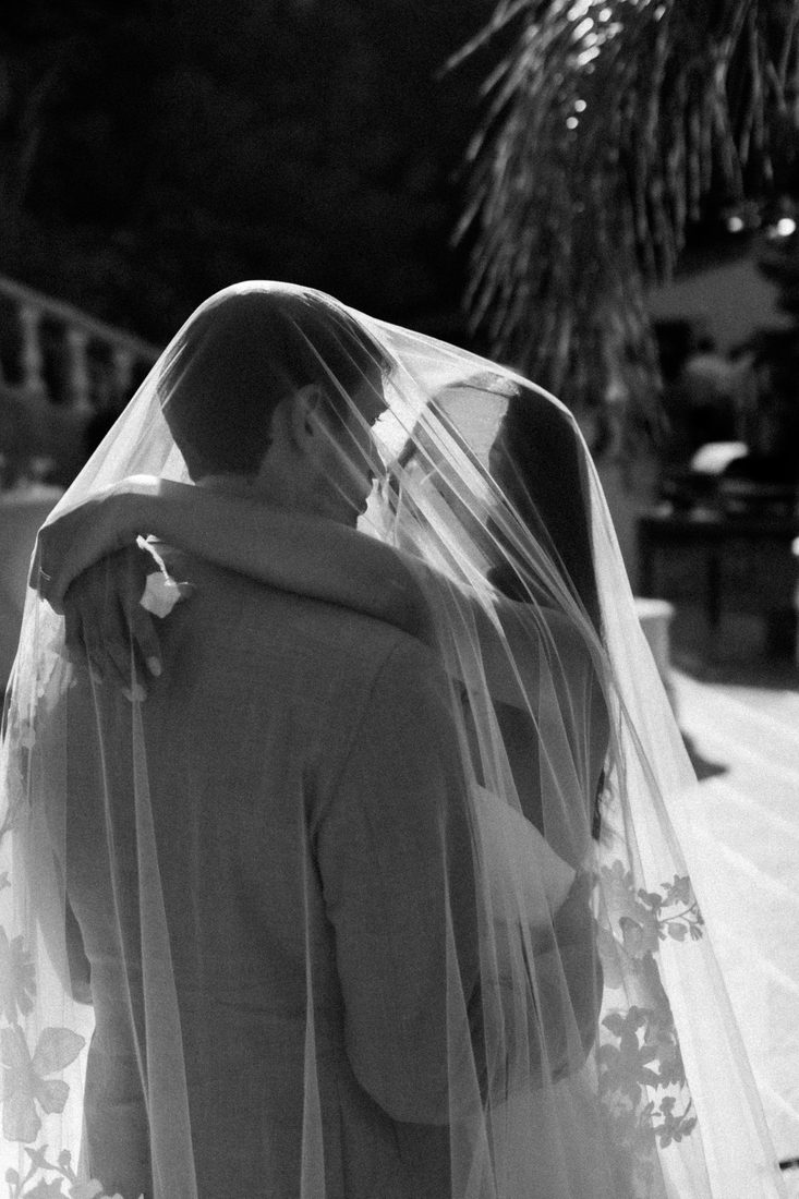 Les mariés enlacés sous le voile, en noir et blanc
