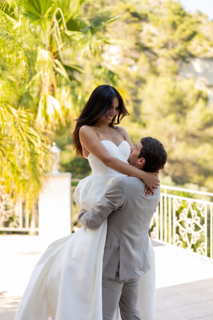 La mariée soulevée dans les bras, sous les palmiers