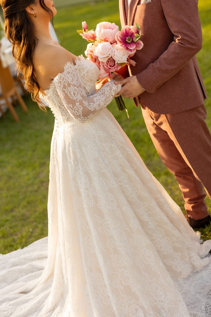 La mariée de dos, robe de dentelle et bouquet