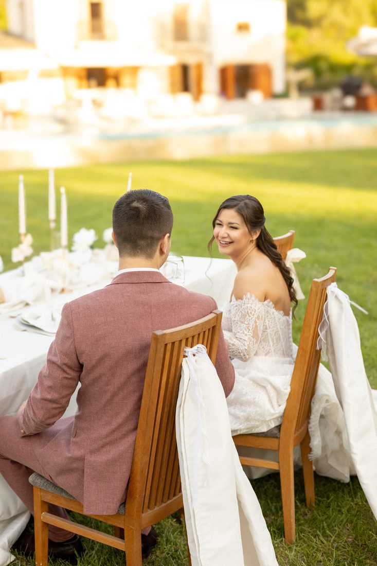 Les mariés attablés dans le jardin, au soleil