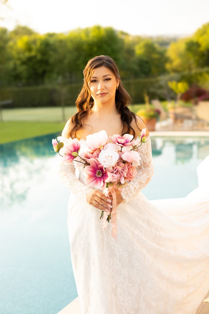 La mariée et son bouquet au bord de la piscine